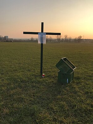 Grünes Kreuz mit Infoblatt und „Grünen Kisten“